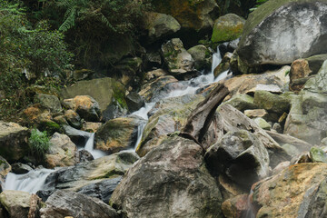 Fototapeta premium Serene Cascade Through Rocky Terrain