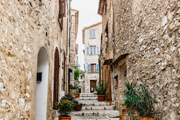 Charming Stone Pathway with Potted Plants and Historic Buildings in Quaint Village