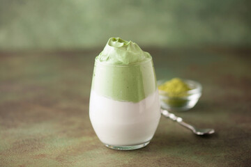 Dalgona Matcha Latte, a creamy whipped matcha in glasses, on green background.