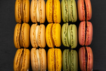 macaroons of different colors on a black background