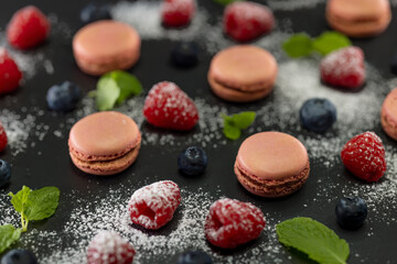 macaroons of different colors on a black background