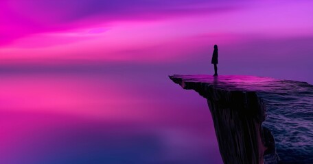 Silhouette of a person standing on the edge of a cliff with a pink and purple sky in the background.