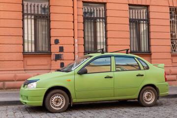 green car on the background of a brown brick wall