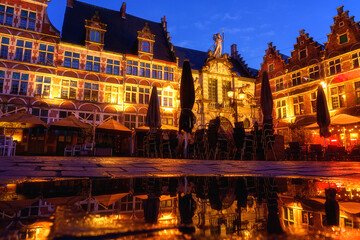 Fototapeta premium Sint Veerleplein medieval square with cafe terraces and old fish market, Ghent, Belgium. Scenic view of historical landmarks, old city architecture at twilight, outdoor travel background