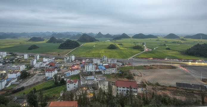 Title: "The Natural Beauty of Luoping"
Description: The image captures the natural landscape of Luoping County, where fields of rapeseed flowers contrast beautifully with the karst topography, composi