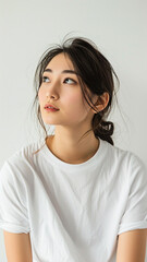 Fototapeta premium A striking portrait of a young Asian woman wearing an white t-shirt, exuding natural beauty and contemporary style.