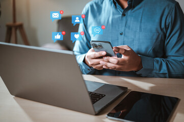 community, contact, email, friends, marketing, touch, information, social, network, mail. A man is using a cell phone while sitting at a desk with a laptop and two other cell phones.