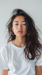 Fototapeta premium A striking portrait of a young Asian woman wearing an white t-shirt, exuding natural beauty and contemporary style.