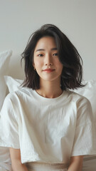 A striking portrait of a young Asian woman wearing an white t-shirt, exuding natural beauty and contemporary style.