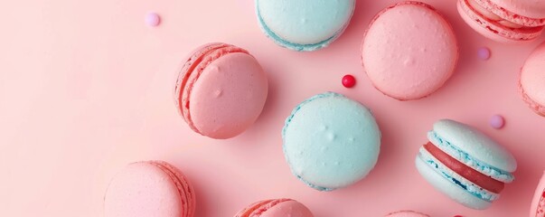 Fototapeta premium Four different colored macarons are displayed on a pink background.