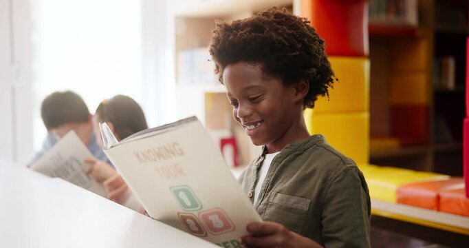 Smiling, black boy and book in classroom for educational development, mind growth and language learning. Student, reading or studying in school library for creative knowledge and storytelling