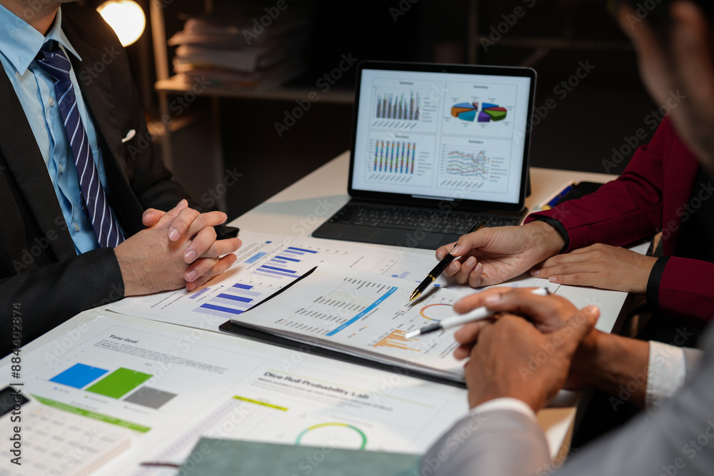 Poster corporate professionals analyzing financial data late into the night, collaborating on a project and