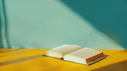 An open book on a yellow table with shadow space for writing