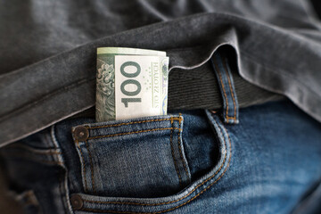 Oszczędności na czarną godzinę. Kieszeń spodni z stu złotowym banknotem. 