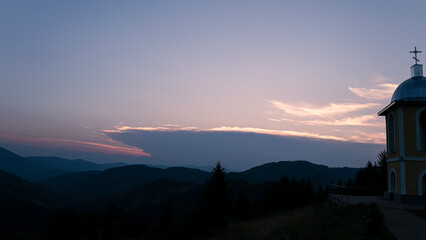 Fototapeta premium Orange sunset with the setting sun behind the mountains