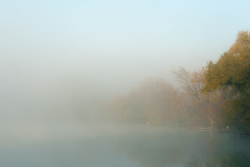 Fototapeta premium Fog over the river on an autumn morning at dawn, natural background.
