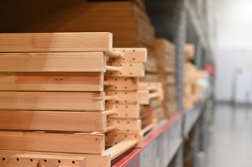 Stacks of wooden frames on a warehouse shelf, showcasing organized storage and inventory management.