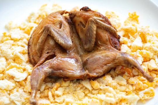 Quail prepared on a plate with pasta and egg crumbs