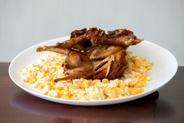 Quail prepared on a plate with pasta and egg crumbs