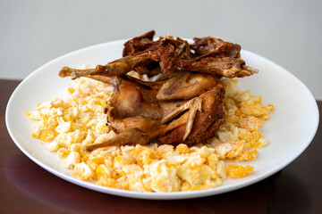 Quail prepared on a plate with pasta and egg crumbs