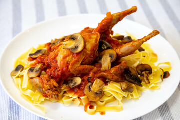 Quail prepared on a plate with pasta and egg crumbs