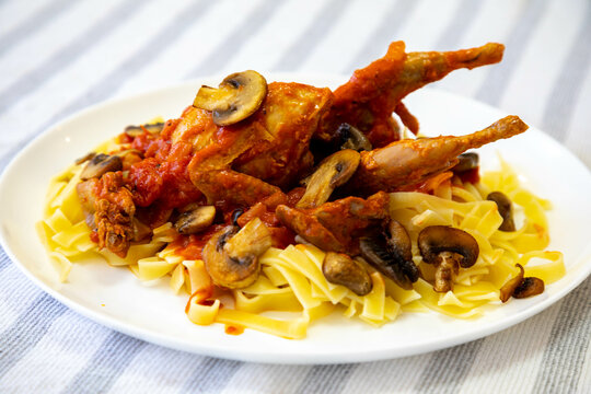 Quail prepared on a plate with pasta and egg crumbs