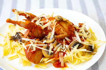 Quail prepared on a plate with pasta and egg crumbs