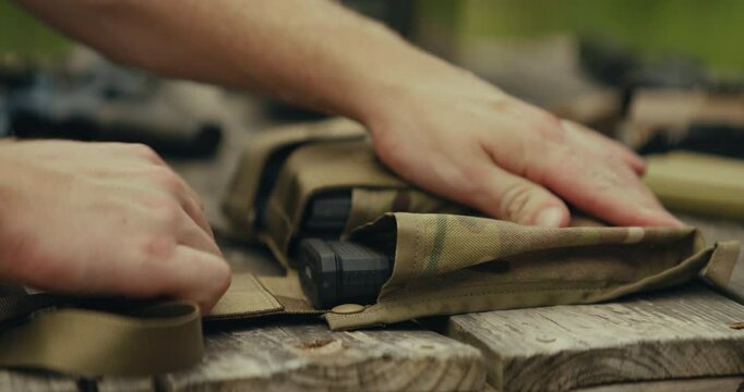 5.56 bullets being grabbed and loaded into a magazine