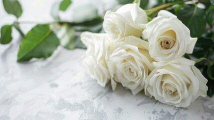 White roses bouquet on white paper top view for wedding invitation card