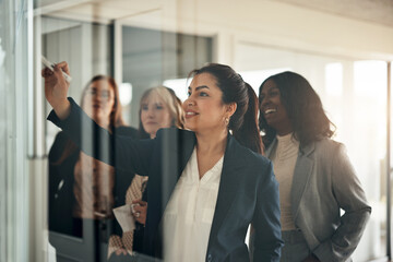 Businesswoman and her team smiling during a brainstorming session in an office