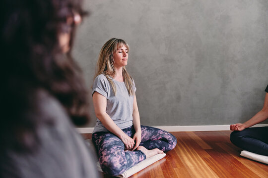 Woman meditating together in a yoga class