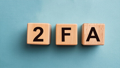 Obraz premium Wooden cubes with abbreviation 2FA, blue background. Two-Factor Authentication. Online security