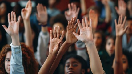 A close-up of diverse students' hands raised in a classroom, eagerly waiting to participate in discussion and learning. In the background