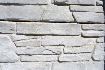 Building materials, gray concrete cement fence made in the form of natural drilled stones.