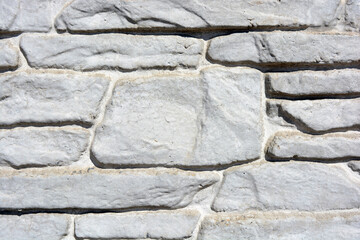 Building materials, gray concrete cement fence made in the form of natural drilled stones.