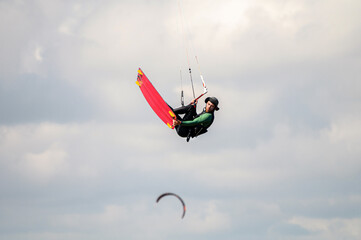 kitesurfer rides the waves at his home spot in the bay. An athlete in a panama hat performs a trick...