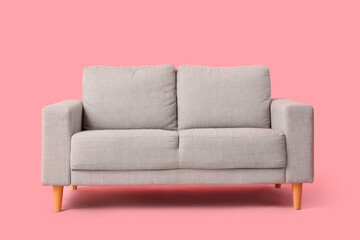 Cozy grey sofa on pink background