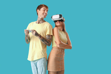 Young couple with VR glasses and mobile phone on blue background