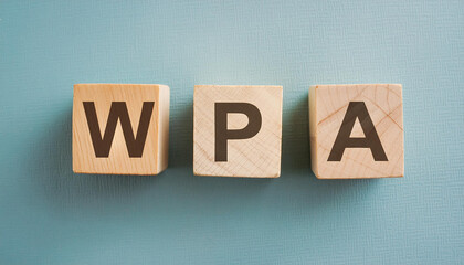 Wooden cubes with abbreviation WPA, blue backdrop. Wi-Fi Protected Access. Internet, online security