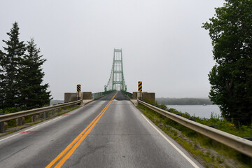 The Deer Isle Bridge in Sedgwick, Maine on a foggy morning as it spans across Eggemoggins Reach to...