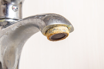 Rusty deposits of hard water on aerator. Plaque and rust on the faucet