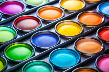 Fototapeta premium A row of colorful paint cans arranged in a row. The colors are bright and vibrant, creating a cheerful and lively atmosphere