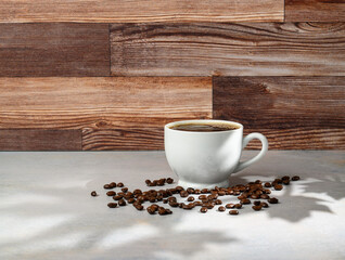 Cup of coffee on white counter with wood plank background