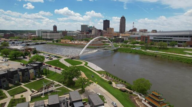 DES MOINES - 6.24.2024 - Excellent aerial view passing over a curved river bridge in downtown Des Moines, Iowa on a sunny day.