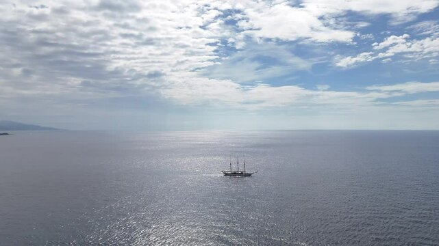 Drone view of a schooner off the coast of Monaco, sailing through the blue Mediterranean waters.