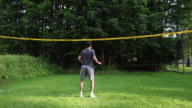 Young volleyball prospect trains his block technique on the lowered volleyball net to better memorize the position. Volleyball skill