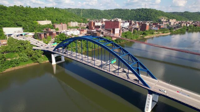 WEST VIRGINIA - 6.24.2024 - Excellent aerial footage circling clockwise around traffic on a bridge on the Monongahela River in West Virginia.