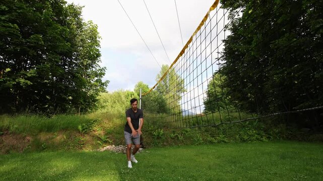 Young volleyball prospect trains his block technique on the lowered volleyball net to better memorize the position. Volleyball skill