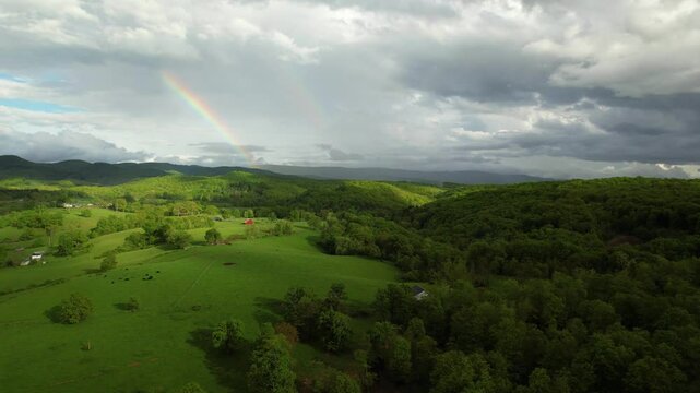 WEST VIRGINIA - 7.5.2024 - Wonderful aerial footage moving over farmland towards a rainbow in West Virginia.