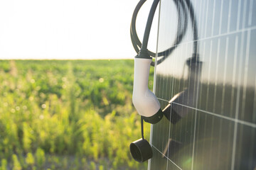 Close up of electric car charging plug with solar panel